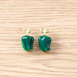 Detailed view of two green bell pepper charms with polished finish and gold metal loops