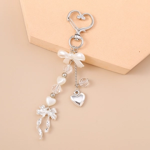 Detailed shot of pearlescent bow and silver heart pendant on a stylish keychain charm