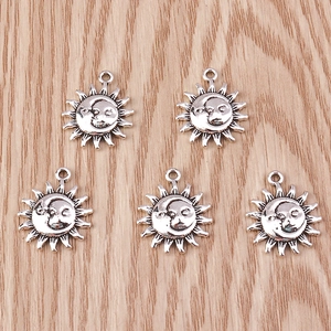 Detail view of five retro sun and moon alloy pendants on a light wood background