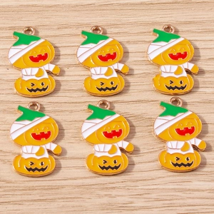 Detailed view of six cute Halloween pumpkin mummy enamel charms with gold metal edges