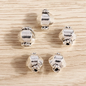 Detalle macro de cinco cuentas de linterna de plata vintage para bisutería artesanal