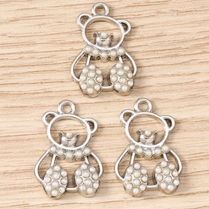 Detailed view of silver bear charms with pearl accents for DIY jewelry making