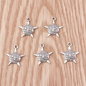 Detail of vintage silver sun and star pendants with intricate facial engravings on wood