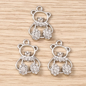 Close-up of silver teddy bear charms with sparkling rhinestones and metal loop for DIY jewelry