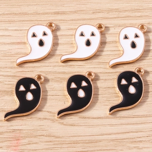 Detail of cartoon ghost charms with enamel finish and gold metal edges for DIY crafting