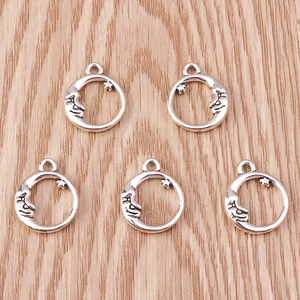 Detail of five silver celestial moon and star alloy pendants on a wooden surface