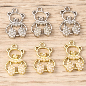 Detailed view of hollow bear charms with pearls and rings for DIY jewelry making