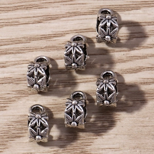 Detail view of retro silver floral beads for jewelry making with vintage textures