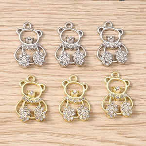 Close-up of cute hollow bear charms with rhinestones in gold and silver plating