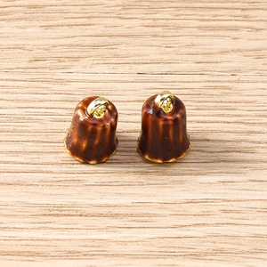 Detailed macro shot of 3D canelé dessert charms with golden rings for jewelry making