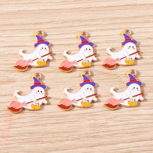Detailed view of white ghost charms with purple wizard hats and pumpkins on wood surface