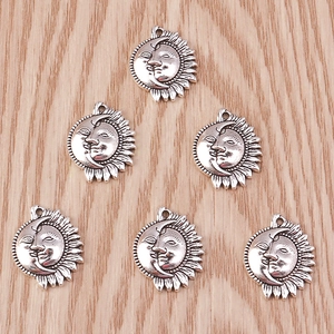 Detailed close-up of antique silver sun and moon charms for DIY jewelry making