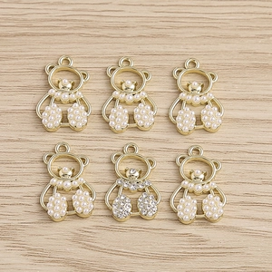 Detailed macro view of 6 cute bear pendants with pearls and rhinestones for DIY jewelry