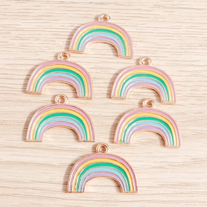 Detail view of rainbow enamel star charms with rose gold metal edges and hanging loops
