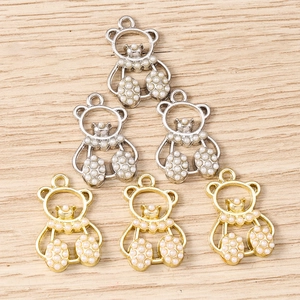 Detailed view of DIY bear charms with pearls and rhinestones in gold and silver finish