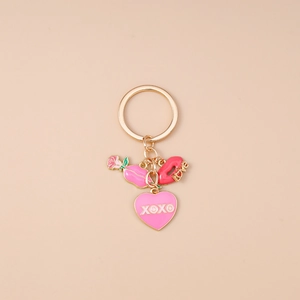 Détail d'un porte-clés doré avec des lèvres LOVE et un pendentif coeur rose XOXO