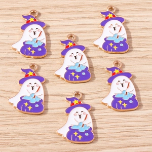 Detail of white ghost pendants with purple wizard hats and cauldrons on wood background
