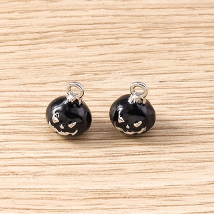 Détail de breloques citrouille en émail noir avec visages argentés pour bijoux Halloween
