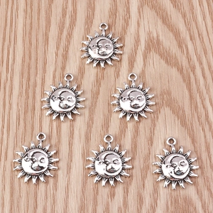 Macro detail of six sun and moon vintage alloy charms on warm wooden background