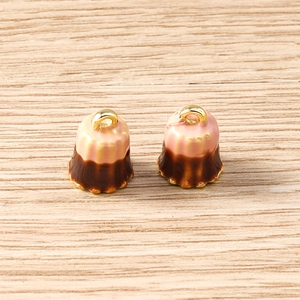 Macro shot of pink canelé dessert charms with golden metal rings on wood background