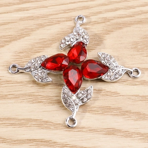 Detail of red flower jewelry connector with crystal petals and silver pave leaves