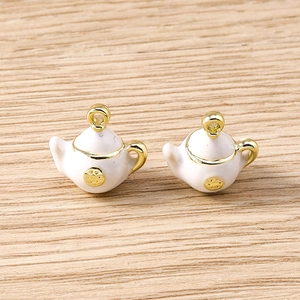 Macro view of white enamel teapot charms with gold alloy frames for jewelry making