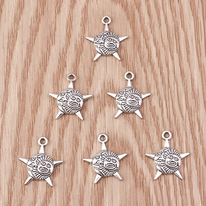 Detailed macro view of vintage antique silver star and sun face pendants for jewelry making