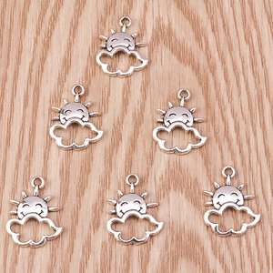 Macro detail of sun and cloud face alloy charms for DIY jewelry in antique silver
