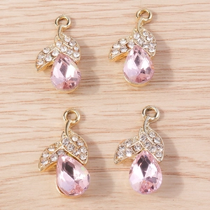 Detailed view of four pink teardrop crystal pendants with gold leaf rhinestone accents