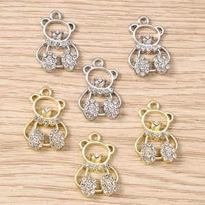 Detailed view of silver and gold bear charms with rhinestones for DIY jewelry making