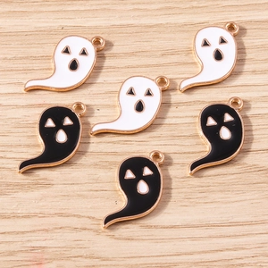 Close-up of cute Halloween ghost charms in black and white enamel with golden alloy loops
