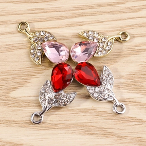Close-up of leaf-shaped jewelry pendants with water-drop crystals and white rhinestones