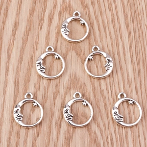Close-up of six crescent moon and star alloy pendants on a rustic wood background