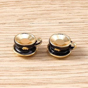 Detailed macro view of miniature black enamel and gold plated teacup charm pendants