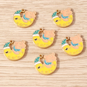 Detailansicht der Emaille-Bär-Mond-Anhänger für DIY-Schmuck auf Holzoberfläche