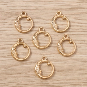 Golden sun moon star pendant charms for DIY jewelry making on wooden background