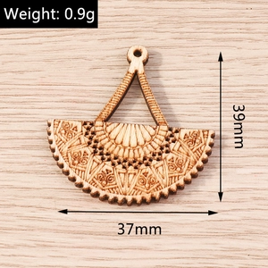 Macro detail of laser-engraved fan-shaped wooden pendant with ethnic patterns and size info