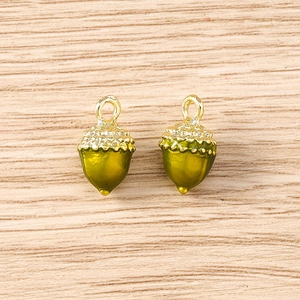 Detailed macro view of olive green enamel acorn charms with golden metal textured caps
