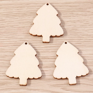 Macro detail of three natural wood Christmas tree pendants with pre-drilled holes for DIY crafts