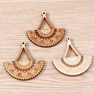Detail of laser cut wooden fan pendants with bohemian carvings for DIY jewelry making