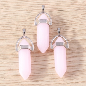 Detailed macro view of three pink hexagonal crystal bullet pendants with silver metal caps