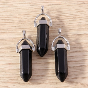 Macro detail of three hexagonal black obsidian bullet pendants with silver metal clasps