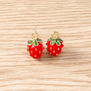 Detailed macro view of two red strawberry charms with gold hooks for DIY jewelry making