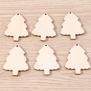 Detail of laser-cut Christmas tree shaped wooden pendants with natural wood grain and hanging holes