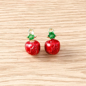 Macro view of 3D red strawberry pendants with gold rings for DIY jewelry making