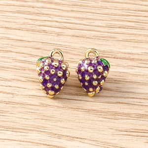 Detailed view of two purple berry charms with gold spots and green enamel leaf accents