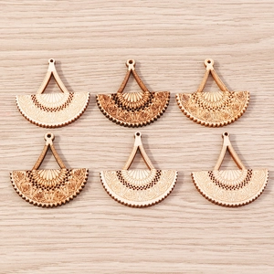 Detailed macro view of laser-cut wooden fan pendants with intricate mandala carvings