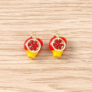 Detailed macro view of 3D pomegranate charms with red crystals for DIY jewelry making