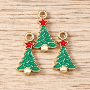 Detailed view of three green enamel Christmas tree charms with red stars for DIY jewelry