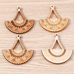 Macro view of laser-cut wooden fan pendants with floral patterns for jewelry making